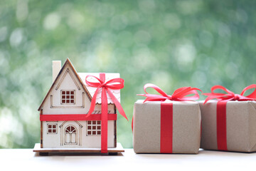 Real estate and Gift new home concept,Model house and gift box with red ribbon for Christmas and New Year's Day or Greeting season