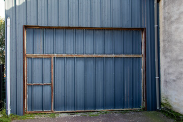 old ancient metal door for access to the barn garage rusted by time wall surface Fence house zinc...