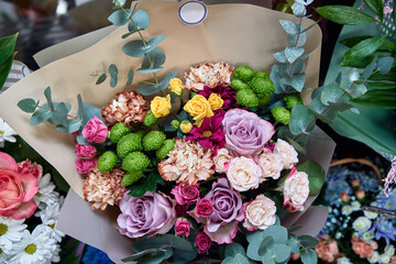 beautiful bouquet of flowers, made up of white and blue flowers with green leaves and stems. flowers are arranged in a circular shape, with a pink ribbon tied around the stems.