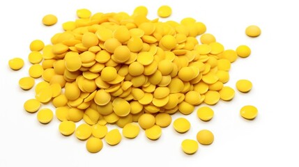  a pile of yellow pills sitting on top of a white table next to a pile of yellow pills on top of a white table.