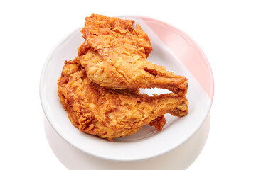 2 large chicken thighs batter and deep fried in plate isolated on white background. fried chicken is a dish consisting of chicken pieces that have been coated with seasoned flour or batter.