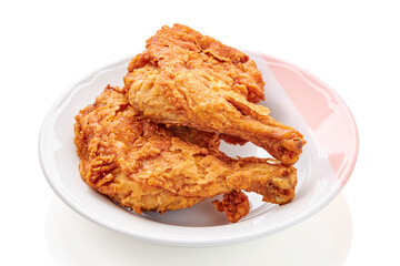2 large chicken thighs batter and deep fried in plate isolated on white background. fried chicken is a dish consisting of chicken pieces that have been coated with seasoned flour or batter.