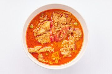 Top view of Panang Curry with Pork top with sliced red chili pepper isolated on white background. Popular Thai food.