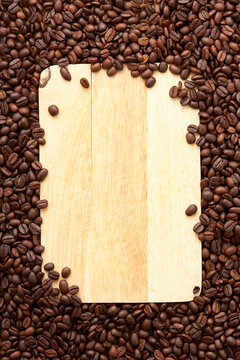 Top view of roasted coffee beans texture background on flat lay in vertical with wooden board (cutting board) free space in center. pattern for design menu drink. coffee beans frame.