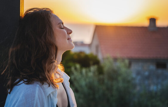 Young cheerful woman enjoying a beautiful moment at sunset. Joy of life concept