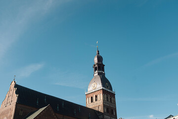Fototapeta na wymiar Beautiful old brick cathedral with high tower peak famous landmark in Riga, Latvia
