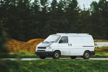 Banner image of white modern delivery shipment cargo courier van moving fast on the highway road to city and urban suburb. Small bus driving on highway day. Business of distribution and logistics