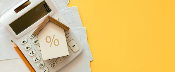 close up top view on home model with calculator and invoice mail on yellow color background with...
