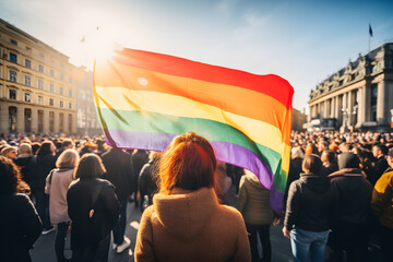 People with rainbow colored LGBTQ flag in demonstration or pride march