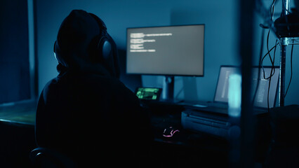 Hacker working on laptop at night in the modern workspace. Hacker or cyber criminal loading...