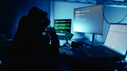 Hacker working on laptop at night in the modern workspace. Hacker or cyber criminal loading transfer data servers systems. Security Breach. Cyber crime, Digital system security - Powered by Adobe