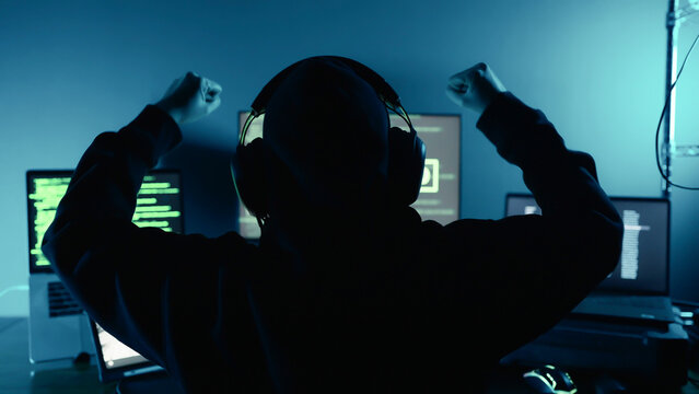 Happy professional hacker raised hand celebration successful after login breaks into data servers and infects their systems with a virus. Security password login, Cyber crime, Digital system security