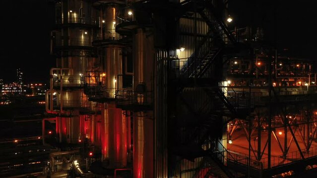 Oil refinery at night with illumination. Close-up. Columns, reactors in color light. Factory at night