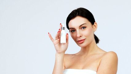 Women's cosmetic procedures. A young attractive, charismatic woman shows a serum or oil for her...