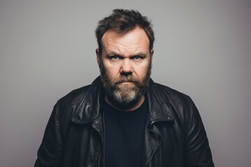 Portrait of an angry bearded man in a black leather jacket.