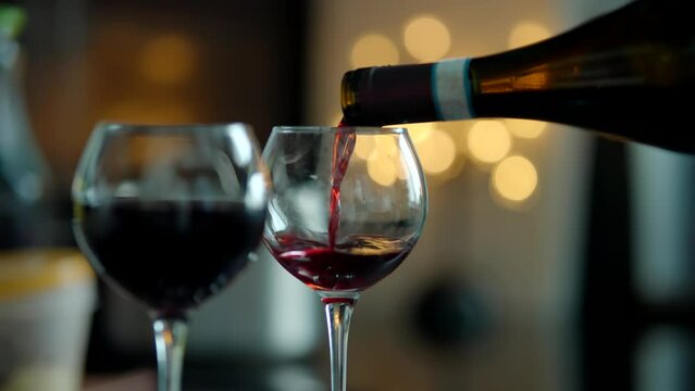 winemaker tasting  flavor and quality of red wine by pouring it into goblet 