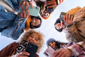 friends using smartphone happily seen from below different cultures