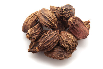Close-up of Organic Black cardamom (Amomum subulatum)  on a white background. Pile of Indian Aromatic Spice. Top view