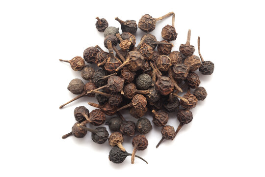 Close-up of Dry Sheetal Chini (Piper cubeba) seeds, isolated on a white background.