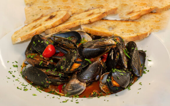 mussels and clams soute with tomato sauce and toasted bread
