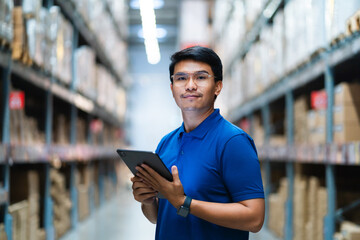 Confident male warehouse worker standing in warehouse warehouse. parcel inspection Quality control Logistics concept. © KANGWANS