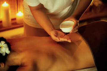 Masseur hands pouring aroma oil on woman back. Masseuse prepare oil massage procedure for customer...