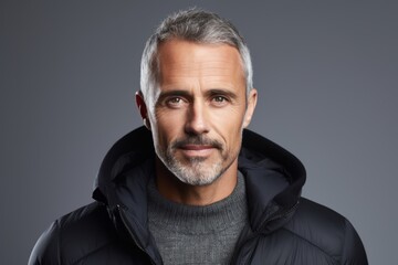 Portrait of a handsome mature man in a black down jacket.