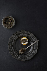 black caviar on a black background - obrazy, fototapety, plakaty