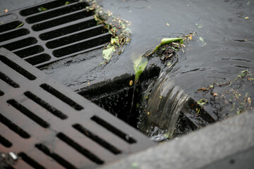 Rainwater is drained into an open storm system. Close-up.