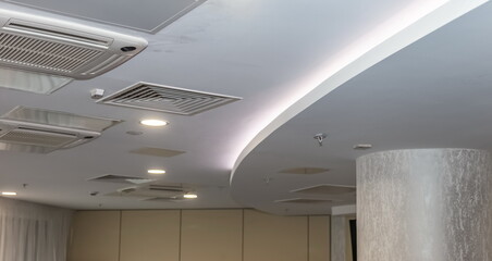 Office ceiling with ventilation grilles, lamps and air conditioners