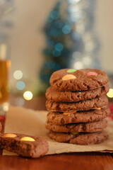 Sweet cookies folded in a column on a wooden table. Blurred bokeh in the background. New Year's delicious baked goods for children.