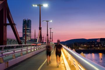 Blurred couple running on the bridge at night