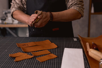 tailor using saddle soap to leather to clean and condition. close up cropped photo