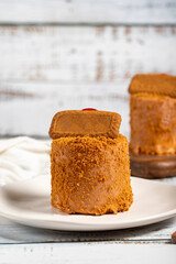 Biscuit cake. Delicious cream cake on a white background. Cake with fruit inside and biscuits on the outside