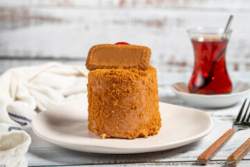 Biscuit cake. Delicious cream cake on a white background. Cake with fruit inside and biscuits on the outside