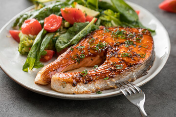 Portion of gourmet grilled salmon steak with vegetables