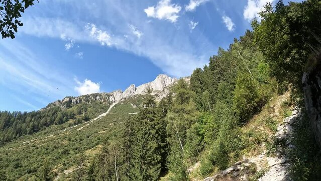 Mountains. Climbing to the top of Le Brevent, French Alps, Chamonix. Beautiful mountain landscape, blue sky, forest, rocks, paragliders. Tourist walk