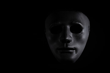 Criminal disguise, black mask on a dark background, theatrical crime - obrazy, fototapety, plakaty