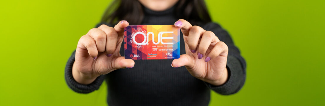 Delhi metro card against solid green screen background, girl holding travel card: October 28 2023