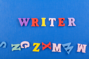 WRITER word on blue background composed from colorful abc alphabet block wooden letters, copy space for ad text. Learning english concept.