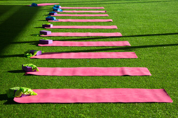 Mats for gymnastics and yoga are laid out on the grass, there are no people.