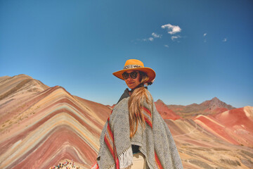Young girl in front of the Vinicunca Rainbow Mountain, Peru South America