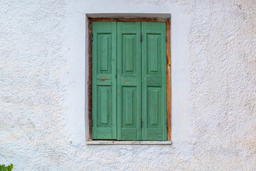 Fototapeta na wymiar Green window on a white wall