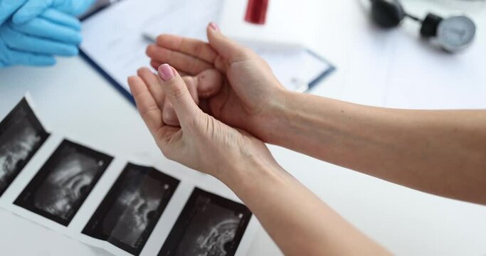 Gynecologist gives woman model of the human fetus in child hand. Abortion refusal and pregnancy