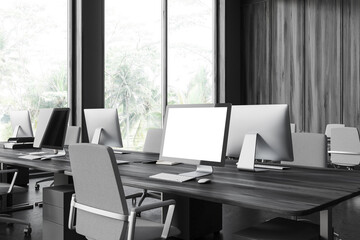 Black coworking interior with pc computer on table with mockup display, window