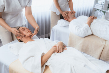 Caucasian couple enjoying relaxing anti-stress head massage and pampering facial beauty skin...