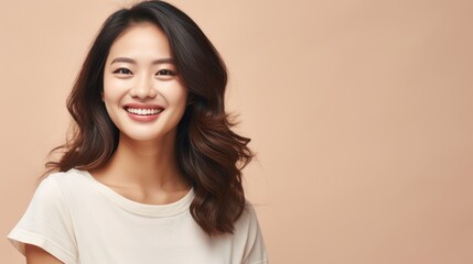 Fototapeta premium Beautiful attractive Asian female smile looking at camera standing against plain background peach color, young student or worker woman in casual with soft skin charming face with long curly hairstyle