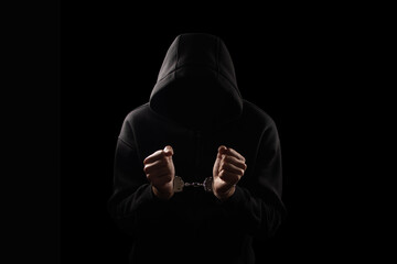 Silhouette of handcuffed male in hoodie, dangerous criminal punished by law. - obrazy, fototapety, plakaty
