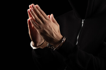 Male hands in handcuffs black background