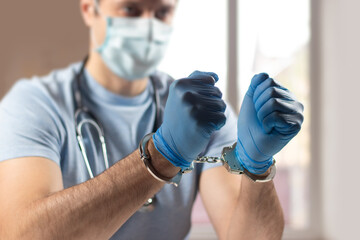 Doctor handcuffed, hands close-up, concept of medical corruption, bribery, crime